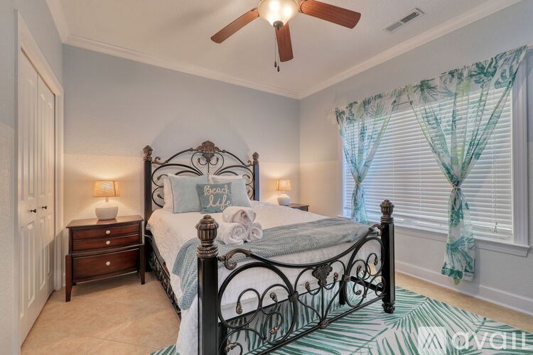 A bedroom with a bed, dresser, and window with curtains.