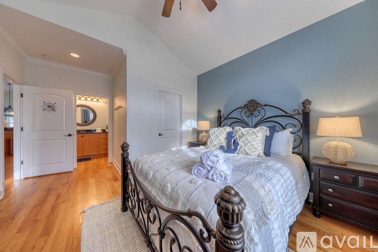 A bedroom with a large bed, a dresser, and a mirror.