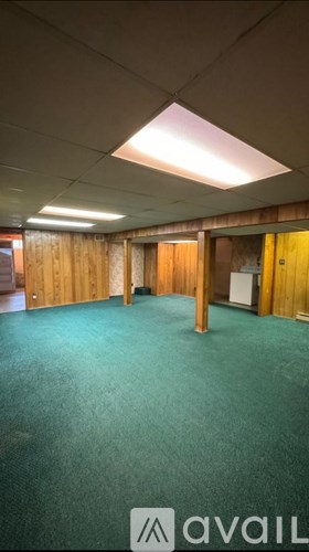 A room with a carpeted floor and wooden walls.