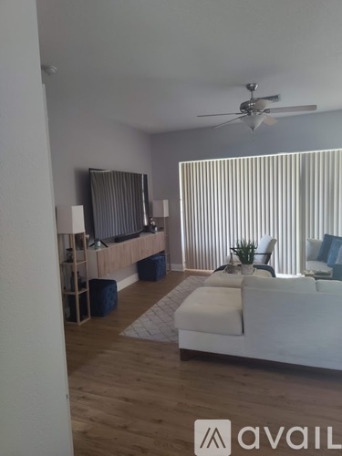 A living room with a white couch and a ceiling fan.