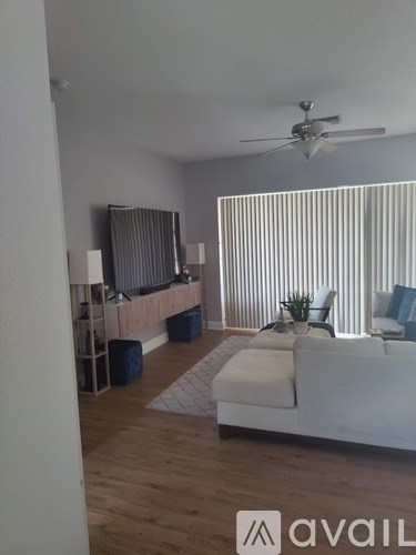 A living room with a white couch and a ceiling fan.