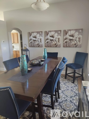 A dining room with a wooden table and blue chairs.