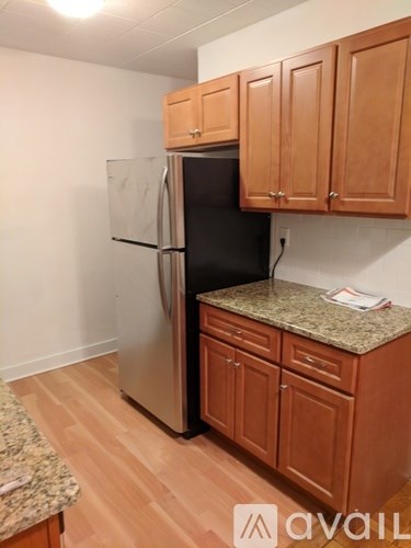 A kitchen with wooden cabinets and a granite countertop.