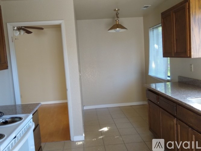A kitchen with a stove top oven and a fan on the ceiling.