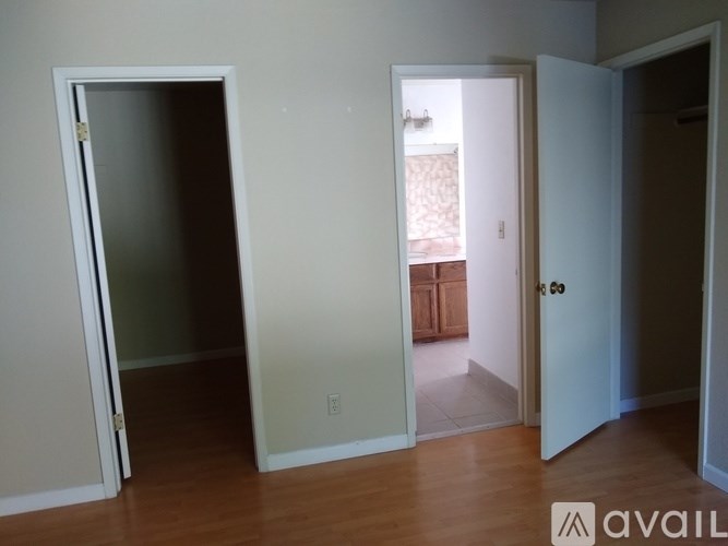 A room with a white door and a wooden floor.