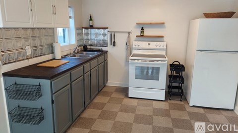 A kitchen with a white fridge, white oven, and white cabinets.