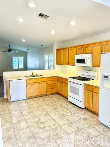 A kitchen with wooden cabinets and white appliances.