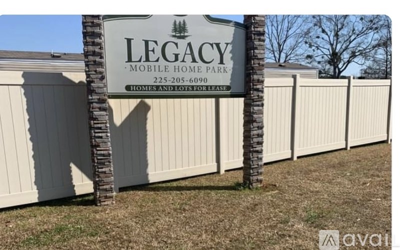 A sign for Legacy Mobile Home Park is displayed in front of a row of mobile homes.