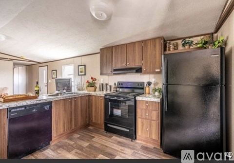 A kitchen with wooden cabinets and black appliances.