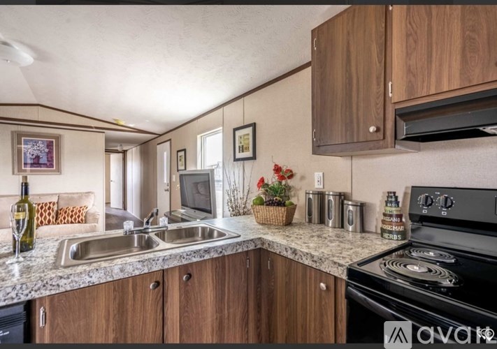 A kitchen with wooden cabinets and a black stove top oven.