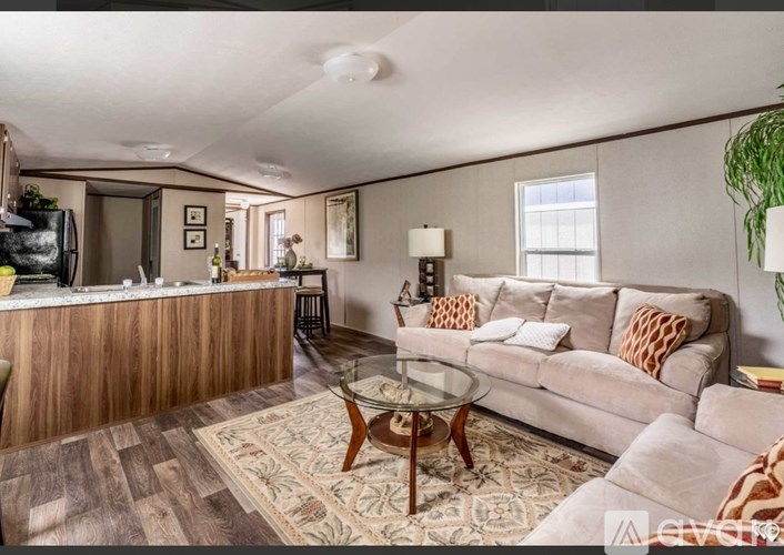 A living room with a couch, coffee table, and a rug.