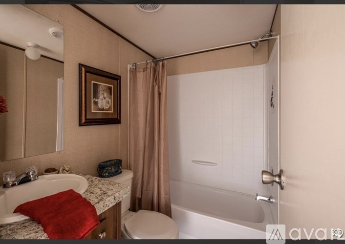 A bathroom with a toilet, sink, and shower.