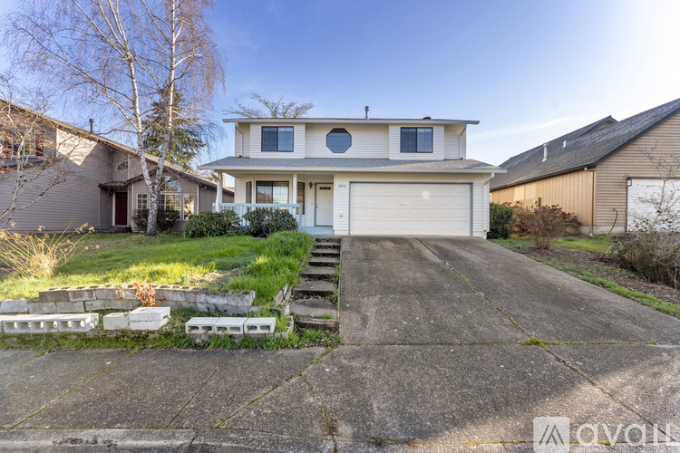 A two-story house with a garage and a front porch.