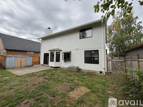 A house with a white exterior and a brown roof is available for rent.