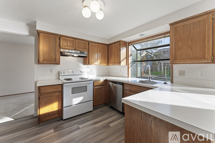 A kitchen with wooden cabinets and a white countertop.