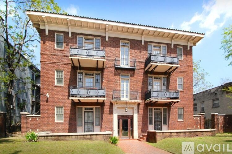 A red brick building with a balcony on the second floor.