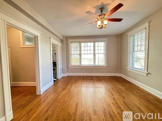 A room with wooden floors and a ceiling fan.