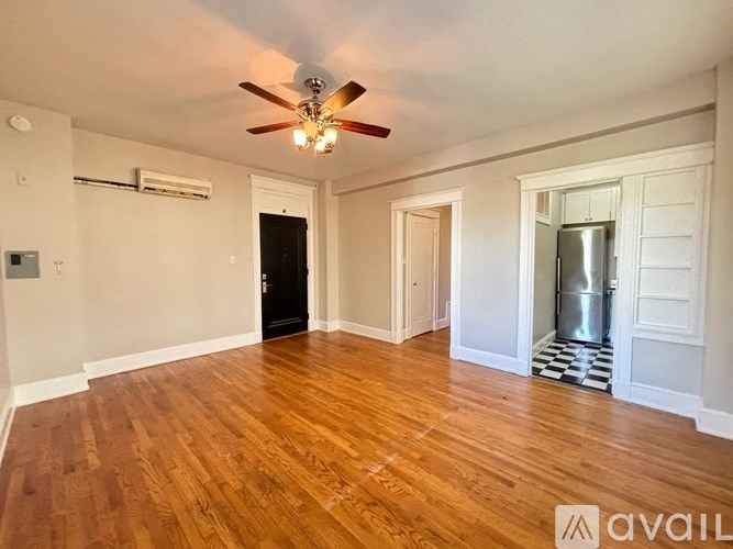 A room with wooden floors and a ceiling fan.