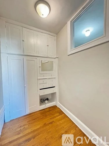 A room with white cabinets and a window.