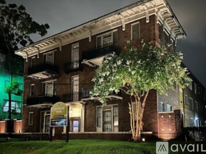 A building with a tree in front of it at night.