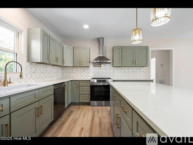 A kitchen with green cabinets and a white countertop.