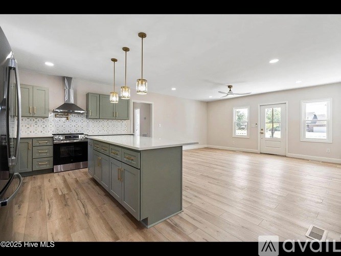 A spacious kitchen with wooden floors and a central island.