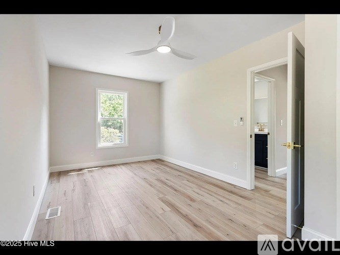 A room with a ceiling fan and a window.
