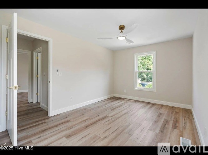 A room with a window and a ceiling fan.