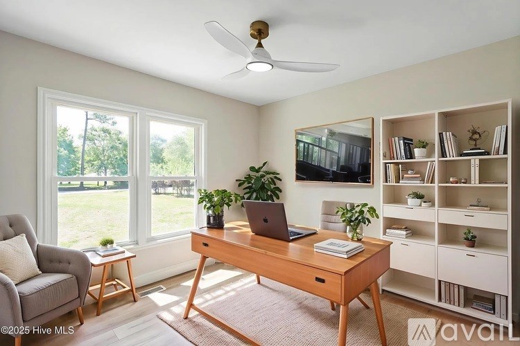 A room with a desk, chair, and a fan.