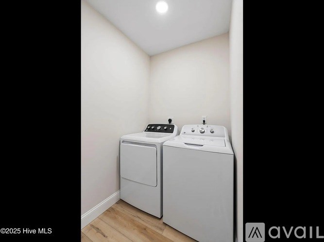 A white washing machine and dryer in a small room.