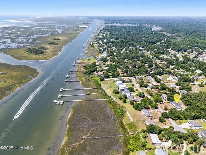 A bird's eye view of a coastal area with a road running parallel to the water.
