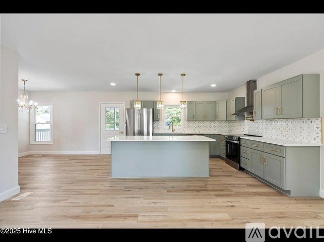 A spacious kitchen with wooden floors and a central island.