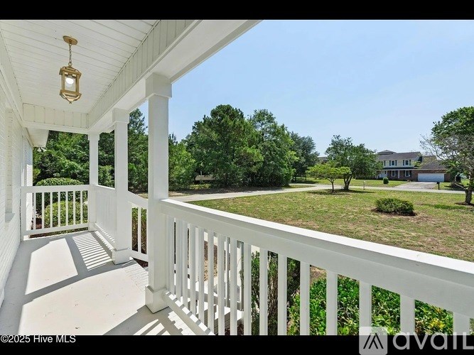 A porch with a white railing and a lantern hanging from the ceiling.