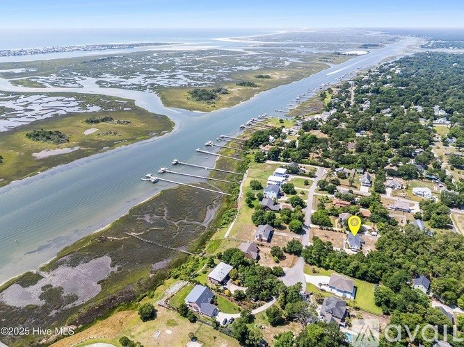 A bird's eye view of a coastal residential area with houses and a body of water.