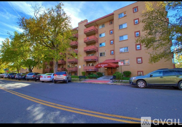 A street view of a building with cars parked in front.