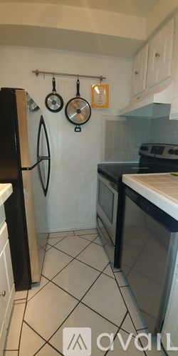 A kitchen with black appliances and white cabinets.