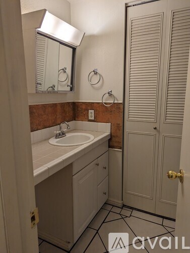 A bathroom with a sink, mirror, and closed door.
