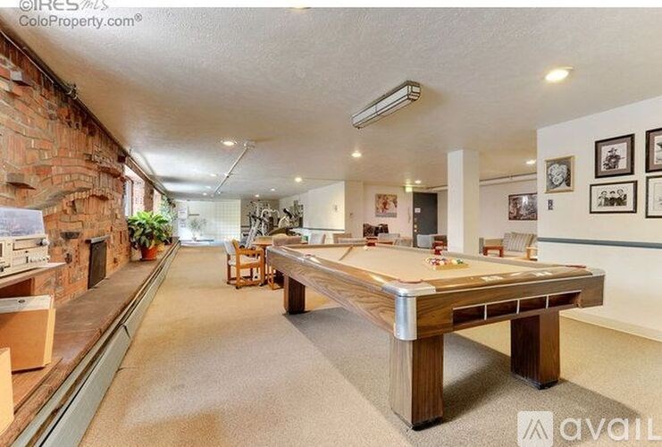 A room with a pool table and a fireplace.