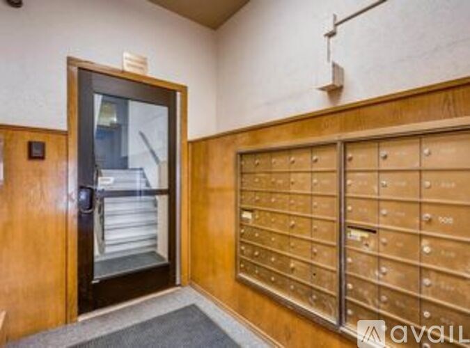 A room with a wall of mailboxes and a door.