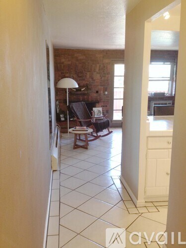 A living room with a brick wall and a white floor.