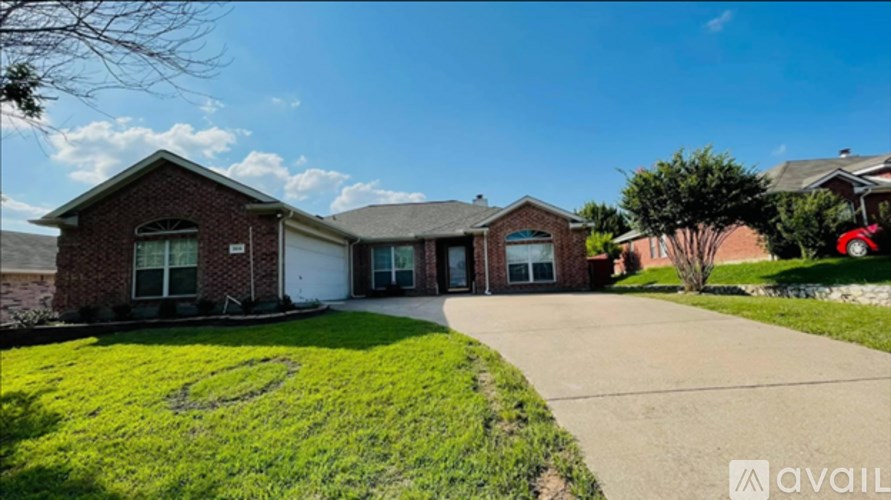 A house with a green lawn and a driveway in front.
