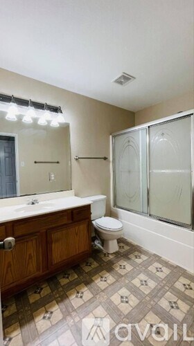 A bathroom with a toilet, sink, and shower.