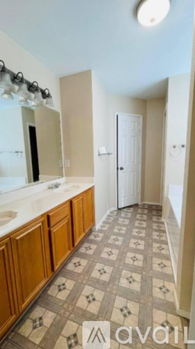 A bathroom with a tiled floor and a sink.