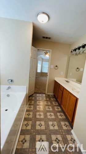 A bathroom with a tiled floor and a white bathtub.