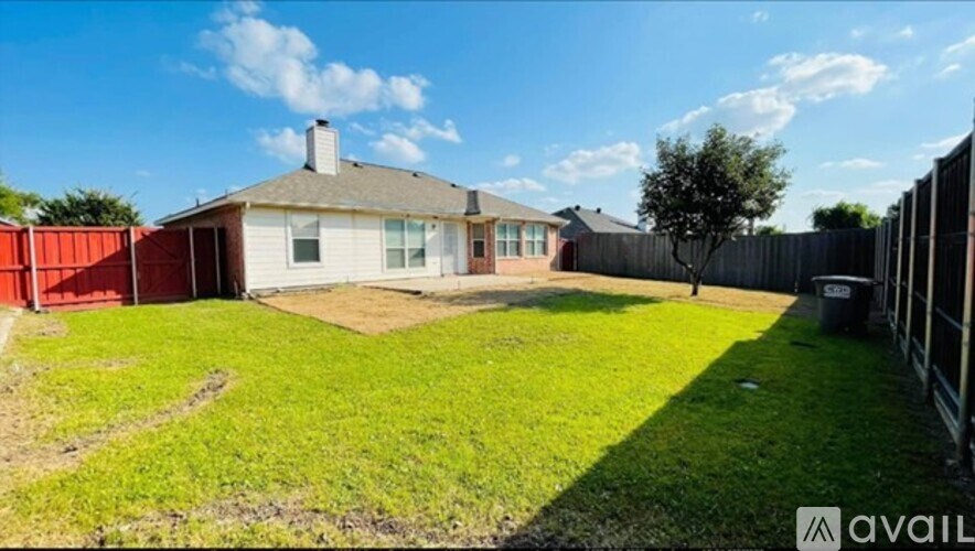 A house with a red fence and a tree in the backyard.