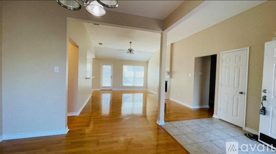 A spacious room with wooden floors and white walls.