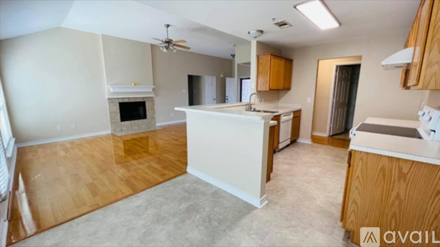 A kitchen with a white countertop and wooden cabinets.