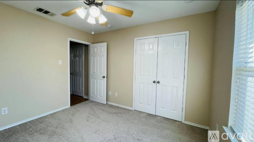 A room with a ceiling fan and two white doors.