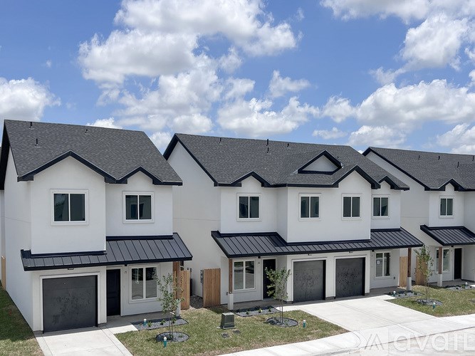 A row of modern houses with black roofs and white walls.