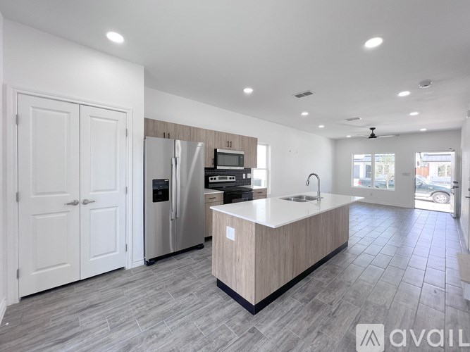A modern kitchen with a central island and a refrigerator.
